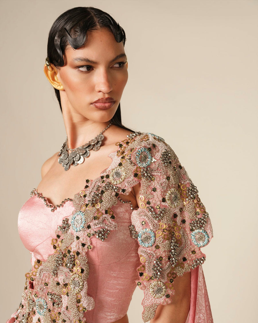 Close-up of a blush pink blouse with an embroidered shoulder drape